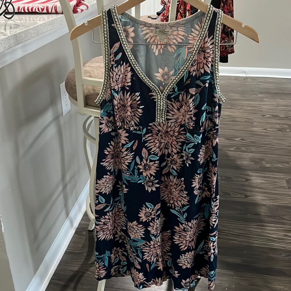 Sleeveless dress. Blue patterned with gold highlights stitching.